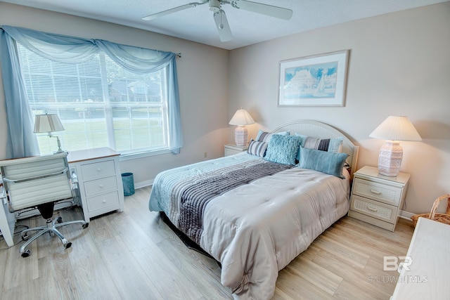 bedroom with light hardwood / wood-style flooring, a textured ceiling, and ceiling fan