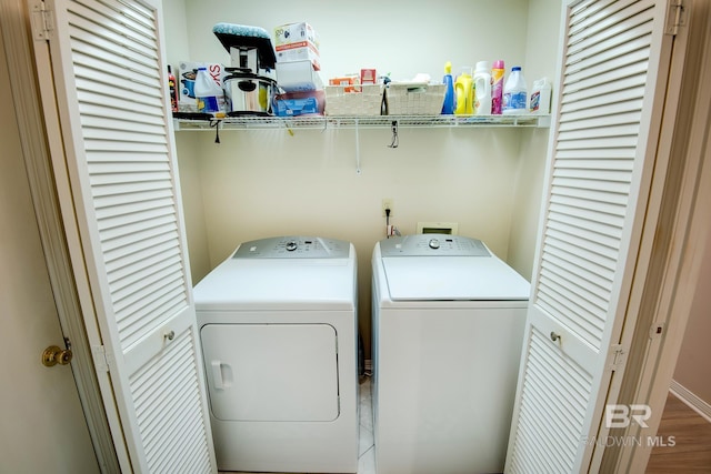 clothes washing area with independent washer and dryer and wood-type flooring