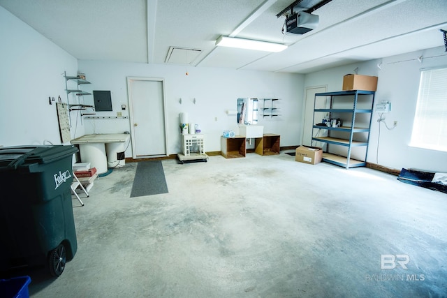 garage with a garage door opener and electric panel