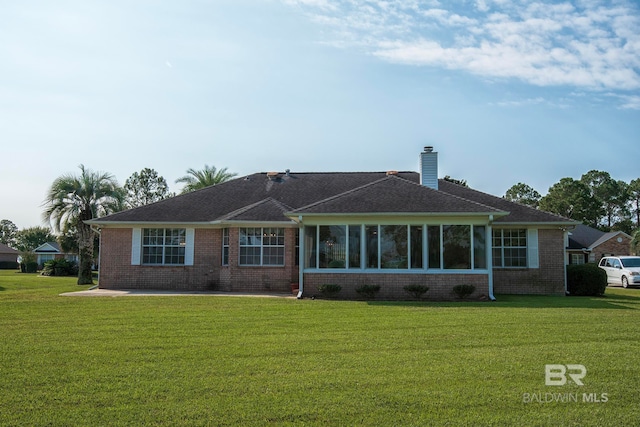 back of property featuring a lawn and a sunroom