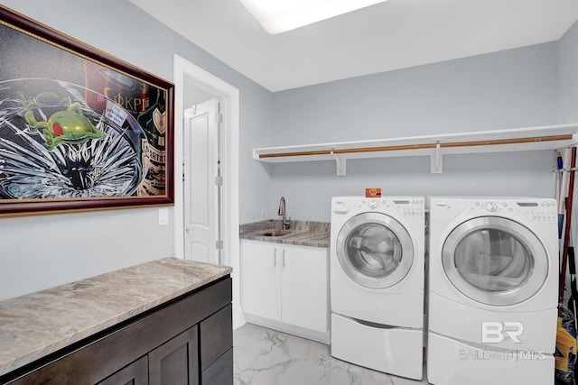 washroom with sink, washing machine and clothes dryer, and cabinets