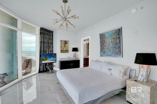 bedroom featuring ensuite bath, a wall of windows, and an inviting chandelier