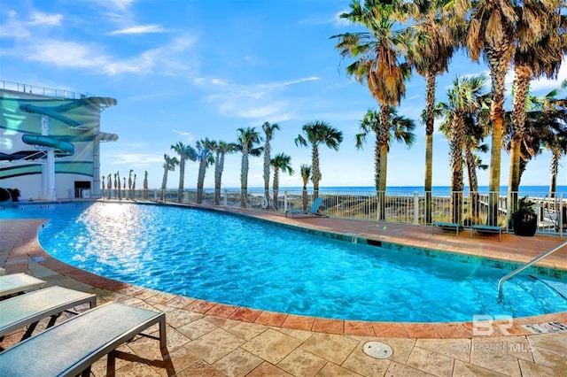 view of pool featuring a water view and a patio area