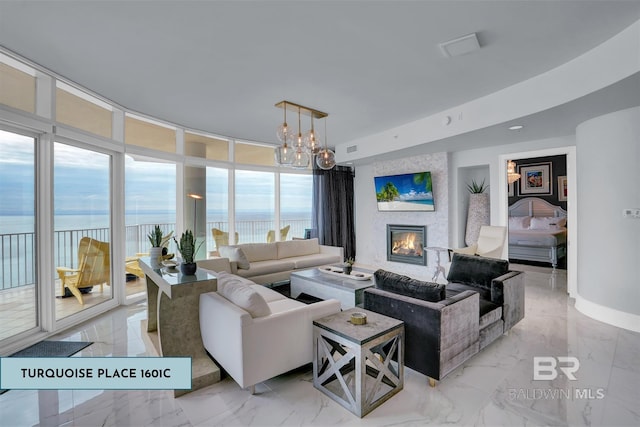 living room featuring a fireplace, expansive windows, and a notable chandelier