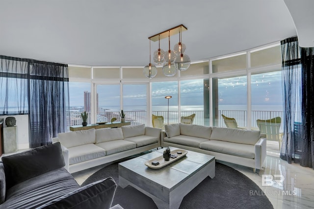 living room featuring an inviting chandelier and a water view