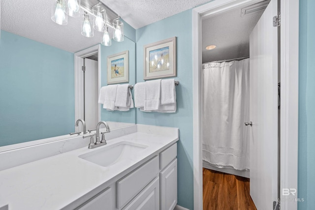 26802 Perdido Beach Blvd Unit 1008, Orange Beach, AL 36561 - full bathroom featuring a textured ceiling, wood finished floors, and vanity