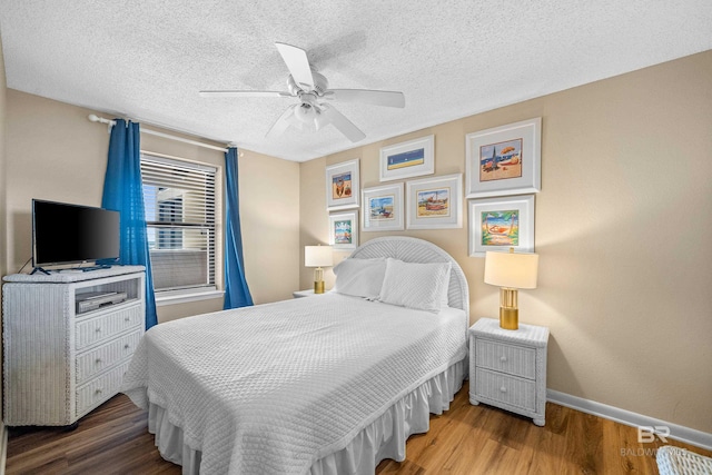26802 Perdido Beach Blvd Unit 1008, Orange Beach, AL 36561 - bedroom with wood finished floors, baseboards, a ceiling fan, and a textured ceiling