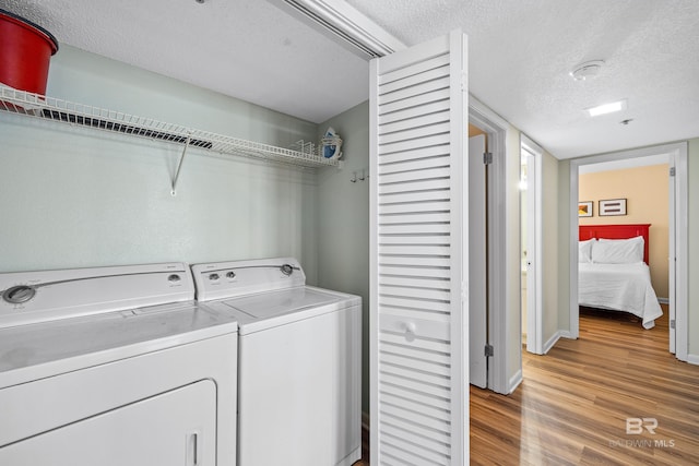 26802 Perdido Beach Blvd Unit 1008, Orange Beach, AL 36561 - washroom featuring separate washer and dryer, light wood-style floors, a textured ceiling, and baseboards