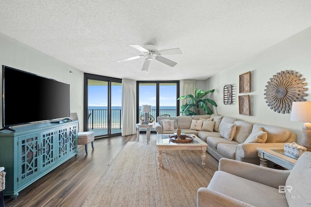 26802 Perdido Beach Blvd Unit 1008, Orange Beach, AL 36561 - living area featuring wood finished floors, a textured ceiling, expansive windows, a ceiling fan, and a water view
