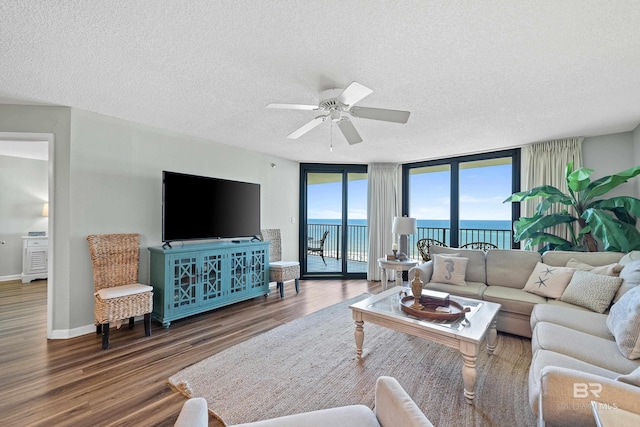 26802 Perdido Beach Blvd Unit 1008, Orange Beach, AL 36561 - living area featuring ceiling fan, wood finished floors, a textured ceiling, expansive windows, and baseboards