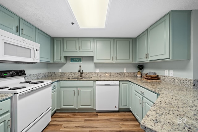 26802 Perdido Beach Blvd Unit 1008, Orange Beach, AL 36561 - kitchen featuring white appliances, a sink, green cabinetry, wood finished floors, and light stone counters