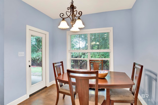 dining area with an inviting chandelier, plenty of natural light, and concrete floors