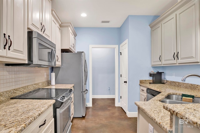 kitchen featuring white cabinets, appliances with stainless steel finishes, light stone countertops, and tasteful backsplash