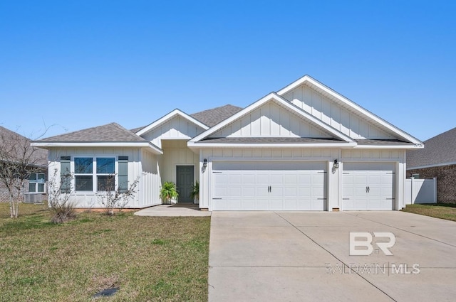 view of front facade with a shingled roof, a front yard, concrete driveway, and an attached garage