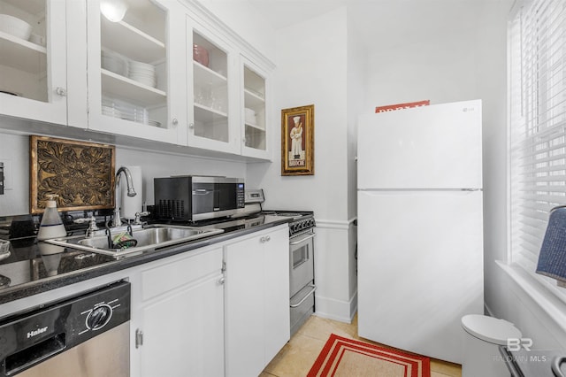 kitchen with sink, white cabinetry, stainless steel appliances, and light tile patterned floors