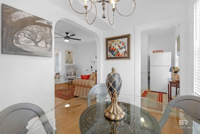 dining room featuring hardwood / wood-style flooring and ceiling fan with notable chandelier