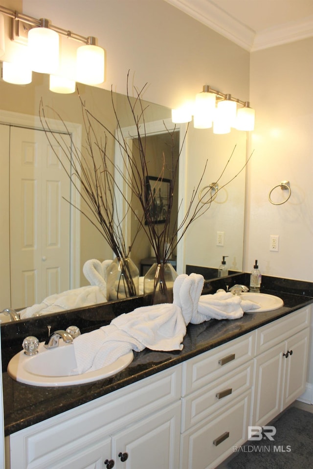 bathroom with vanity with extensive cabinet space, dual sinks, and ornamental molding