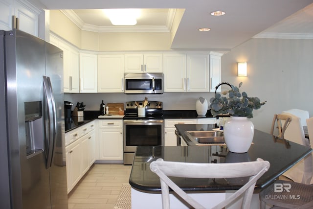 kitchen with white cabinetry, ornamental molding, light hardwood / wood-style flooring, appliances with stainless steel finishes, and sink