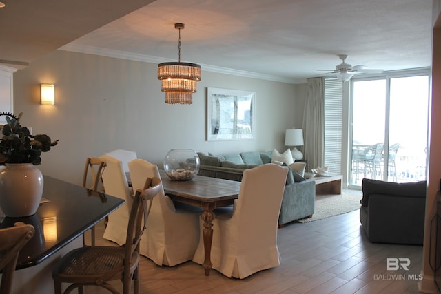 dining area with a wealth of natural light, ceiling fan with notable chandelier, crown molding, and hardwood / wood-style flooring