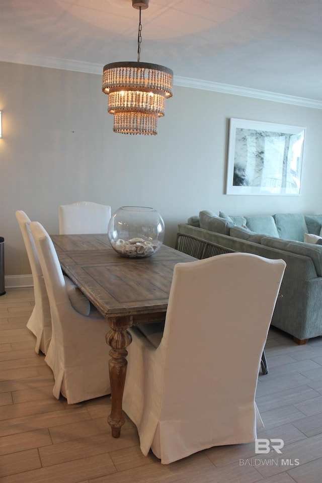 dining space with a notable chandelier, crown molding, and hardwood / wood-style floors