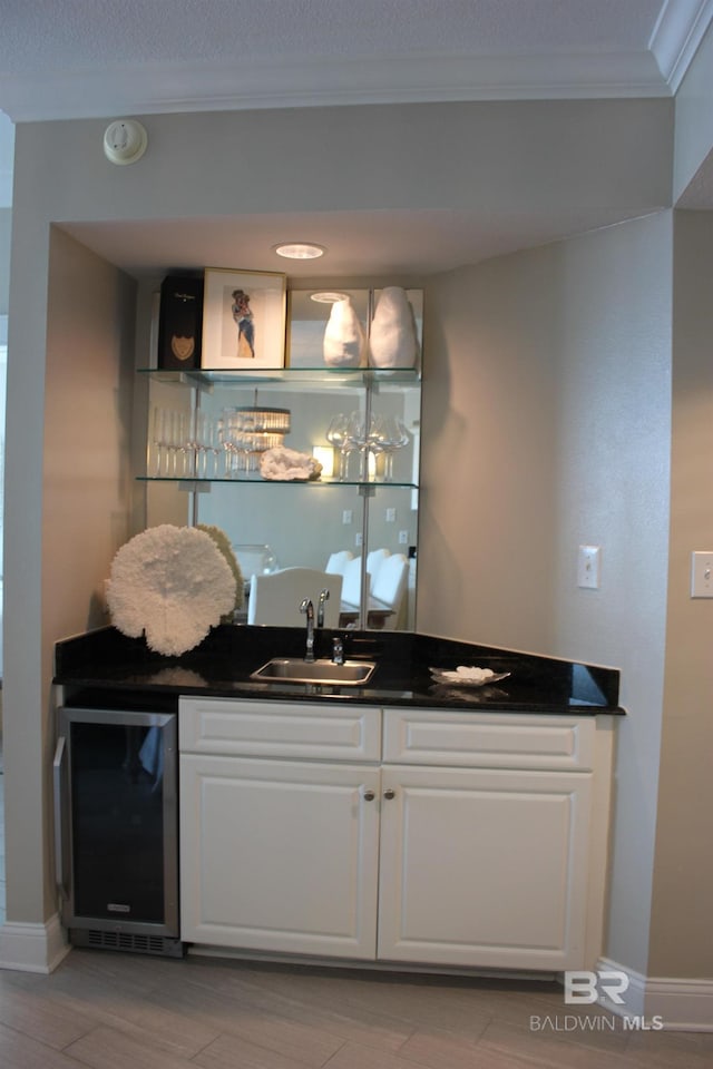 bar featuring white cabinetry, sink, crown molding, and wine cooler