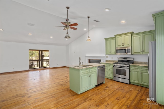 kitchen featuring green cabinets, appliances with stainless steel finishes, an island with sink, and a sink