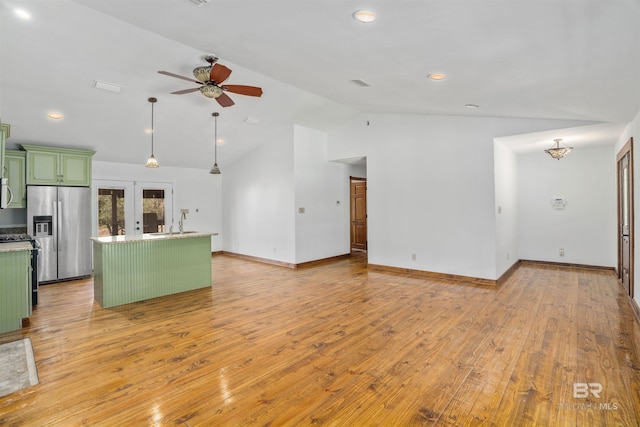 unfurnished living room featuring light wood finished floors, visible vents, ceiling fan, vaulted ceiling, and french doors