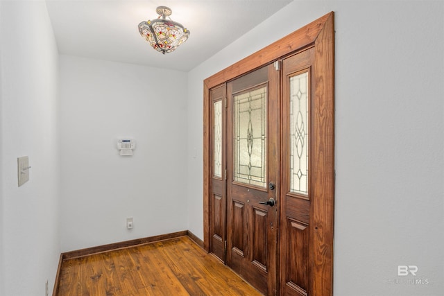 entryway with baseboards and wood finished floors
