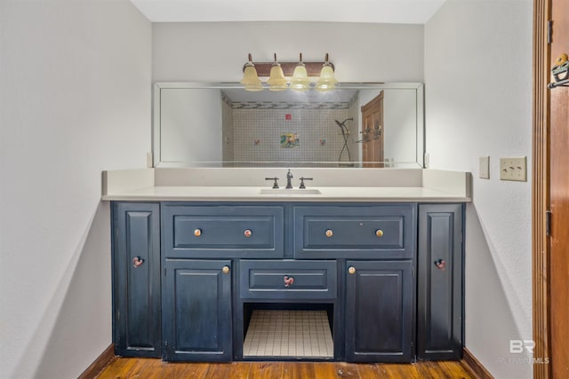bathroom featuring vanity, baseboards, and wood finished floors