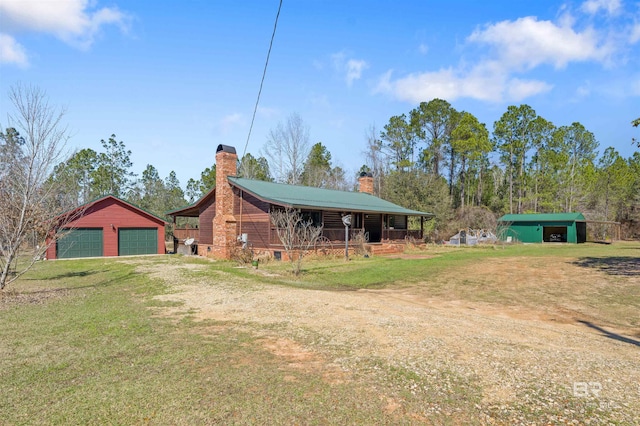 exterior space with driveway, a garage, and an outbuilding