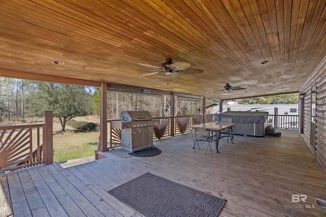 deck with a hot tub, a ceiling fan, and area for grilling