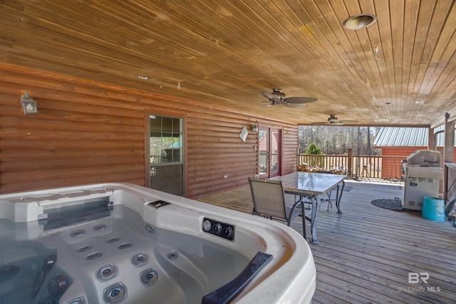 deck featuring outdoor dining space, ceiling fan, and a hot tub