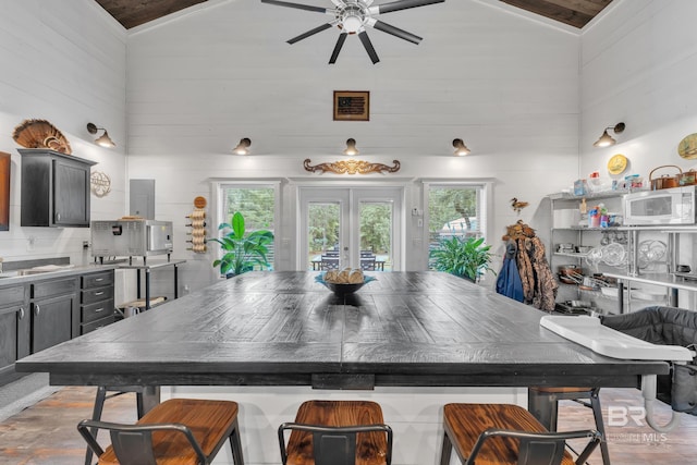 30857 Cypress St, Perdido Beach, AL 36530 - kitchen featuring vaulted ceiling, a ceiling fan, white microwave, wooden walls, and french doors