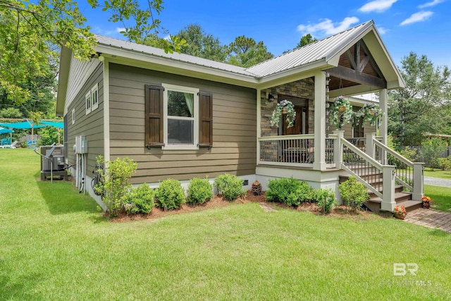 30857 Cypress St, Perdido Beach, AL 36530 - view of front of home with a front lawn, a metal roof, stone siding, and a porch