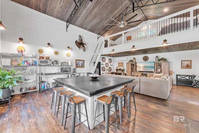 30857 Cypress St, Perdido Beach, AL 36530 - kitchen with white microwave, wood finished floors, a ceiling fan, high vaulted ceiling, and a wood ceiling with exposed beams