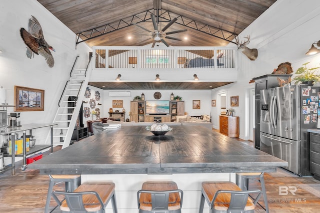 30857 Cypress St, Perdido Beach, AL 36530 - kitchen with stainless steel fridge, high vaulted ceiling, a ceiling fan, light wood-style flooring, and a breakfast bar area