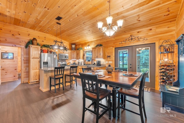30857 Cypress St, Perdido Beach, AL 36530 - dining room featuring vaulted ceiling, wood ceiling, wood walls, a chandelier, and dark wood-style floors