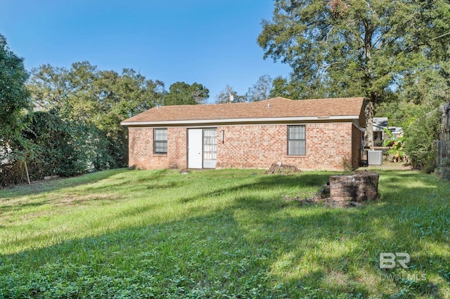 back of property with a lawn and cooling unit