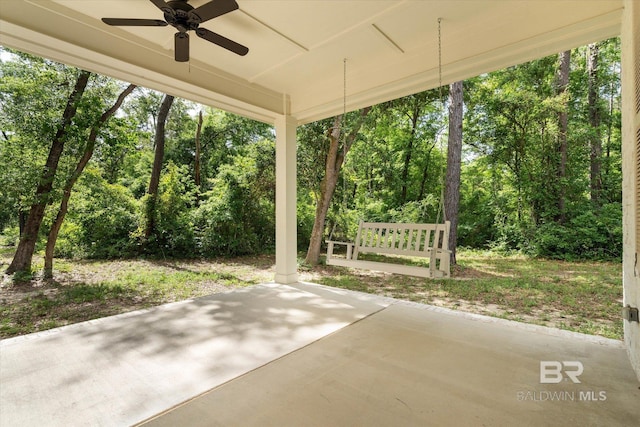 view of patio / terrace featuring a ceiling fan and a forest view