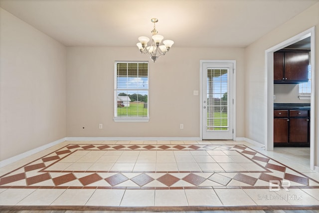 10966 Brighton Dr, Chunchula, AL 36521 - unfurnished dining area with a chandelier, light tile patterned floors, baseboards, and inlaid floor details