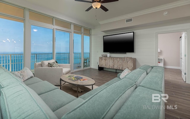 living room featuring visible vents, crown molding, wood finished floors, baseboards, and ceiling fan