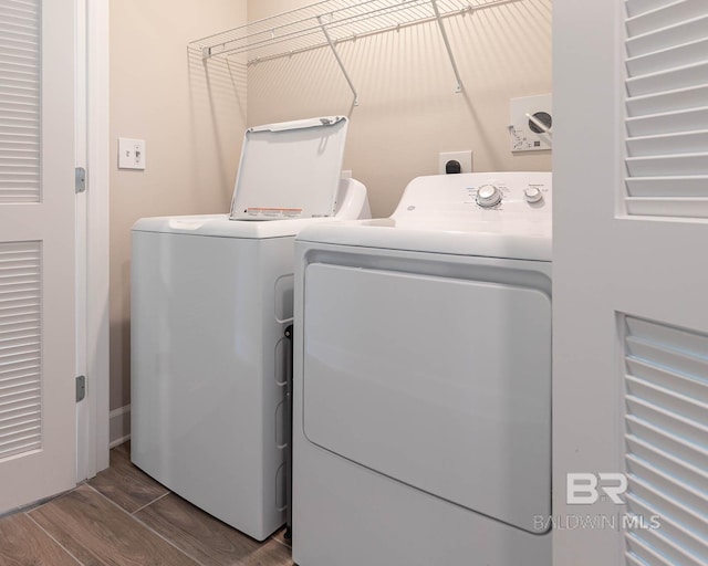 laundry area featuring washing machine and clothes dryer and wood finished floors