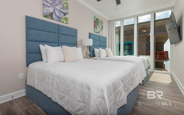 bedroom featuring crown molding, baseboards, ceiling fan, and wood finished floors
