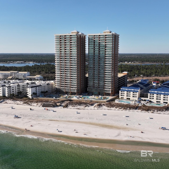 view of building exterior with a beach view and a water view