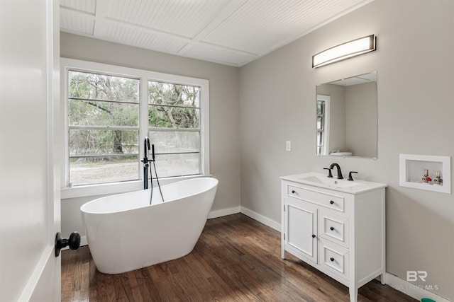 bathroom with vanity, hardwood / wood-style floors, and a bathing tub