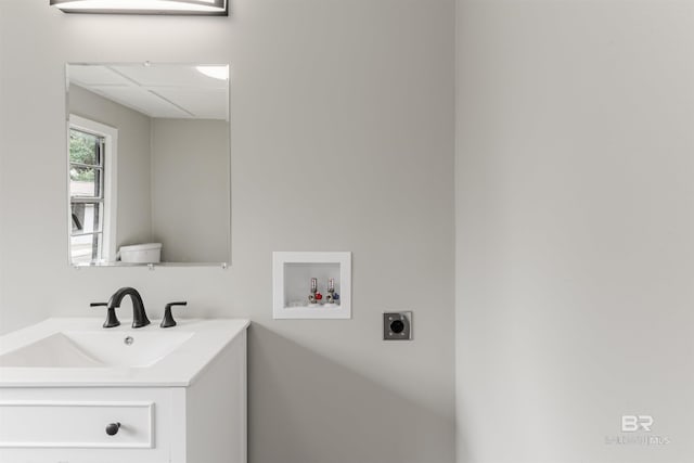 bathroom featuring vanity, a drop ceiling, and toilet