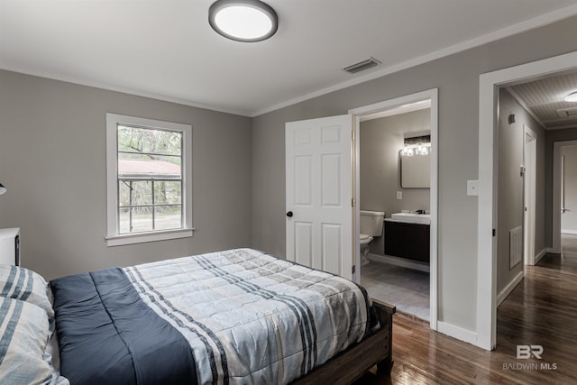 bedroom featuring dark wood-type flooring, connected bathroom, and crown molding