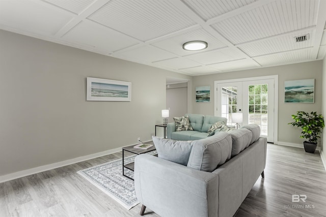 living room with coffered ceiling, light hardwood / wood-style floors, and french doors