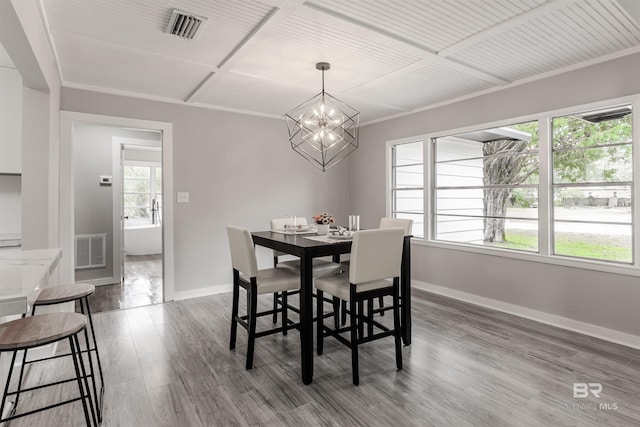 dining room with coffered ceiling, hardwood / wood-style flooring, ornamental molding, and a chandelier