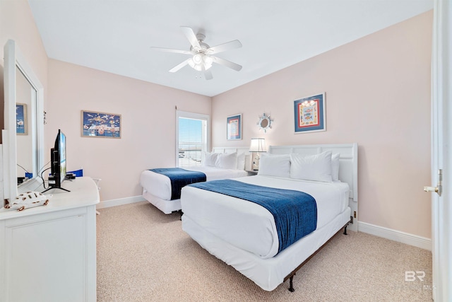 bedroom featuring light carpet, a ceiling fan, and baseboards